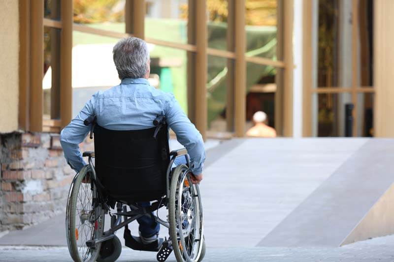 man in wheelchair outside office